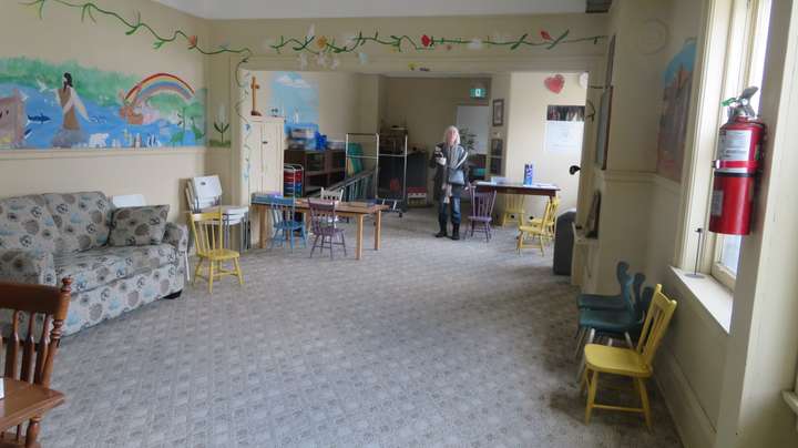 A photo showing both rooms from one end, Judith standing in the second room
